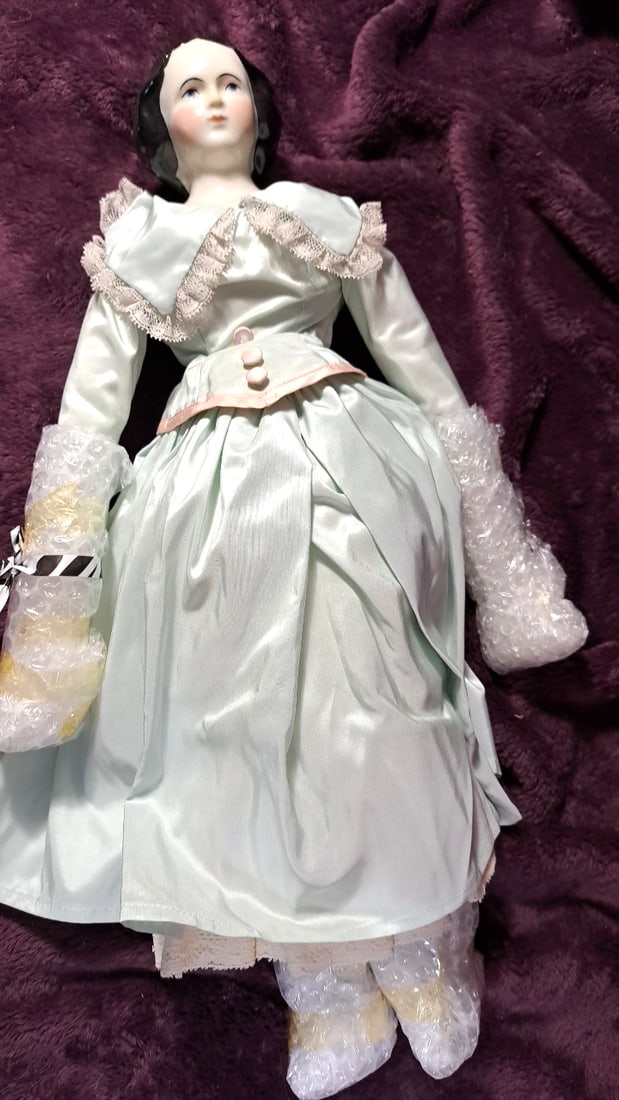 Porcelain Lady Doll with Black Hair, Blue Eyes and Pale Mint Satin Lace Dress: 20x12x10 4lbs High Estimate: 45 Low Estimate: 20