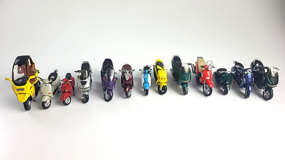 Lot of 13 Model Scooters Vespa, Peugeot, Aprilia, Honda, Various Colors: 12 x 6 x 2 1.5 lb Low Estimate: 50.00 High Estimate: 120.00