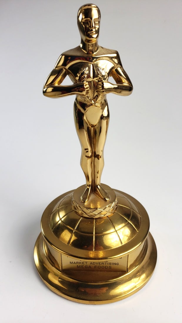 R.S. Owens & Co. 1980 Food Store Market Advertising Mega Foods Gold Trophy Statuette: 5 x 13 x 5 3 lb Low Estimate: 10.00 High Estimate: 25.00