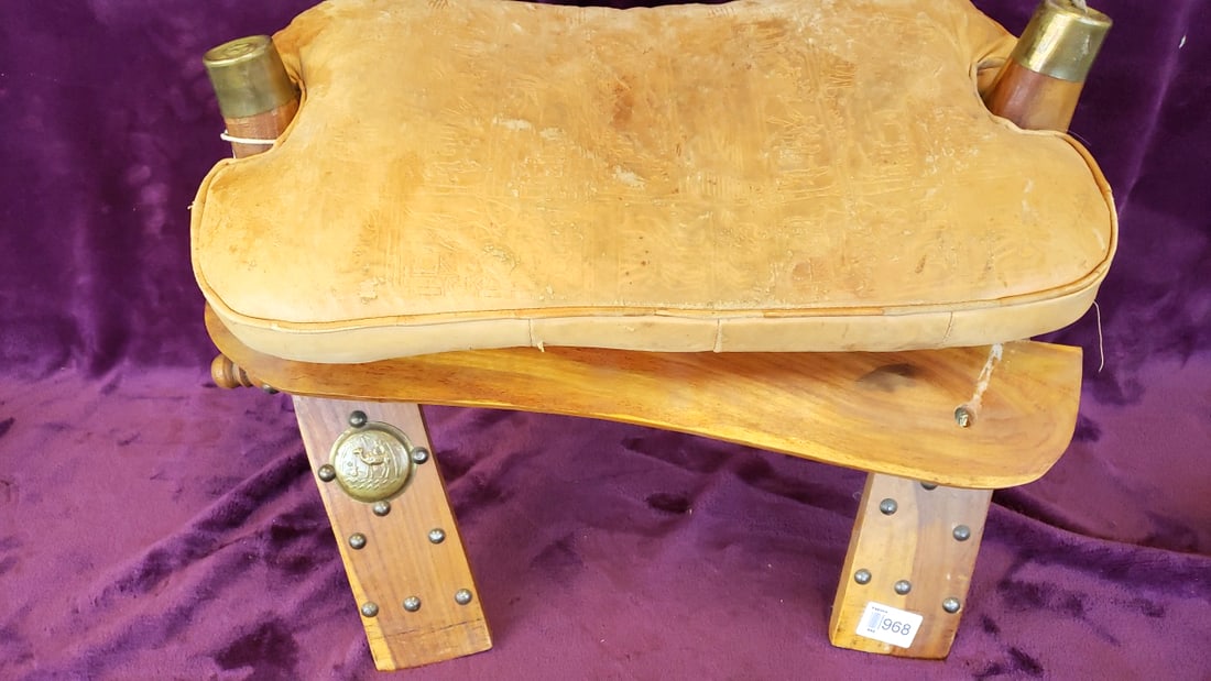 Wood and Leather Camel Saddle Stool with Brass Caps and Medallions: 25 x 17 x 13 12 lb Low Estimate: 50.00 High Estimate: 275.00