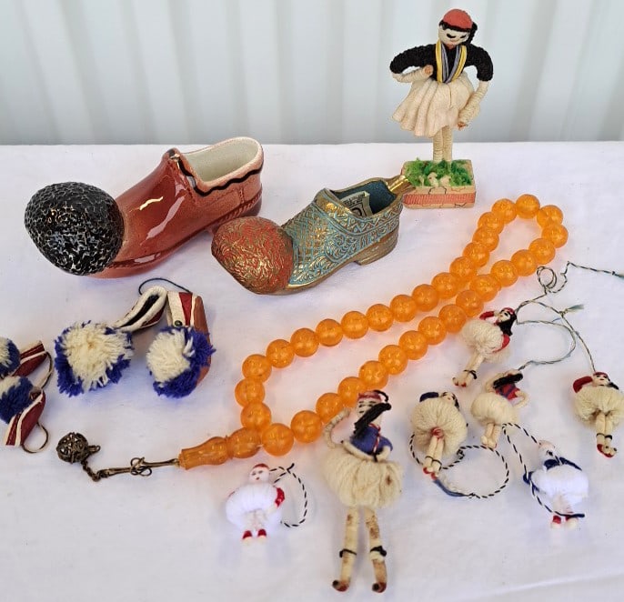 Vintage Greek Souvenir Lot Ceramic Tsarouchi Brass Shoe Ashtray Beads Evzone Dolls: Beads are plastic. Ceramic shoe has a white mark on its top that is not a chip. Its under the glaze. 8 x 8 x 3in. 2lb Low Estimate: 15.00 High Estimate: 50.00