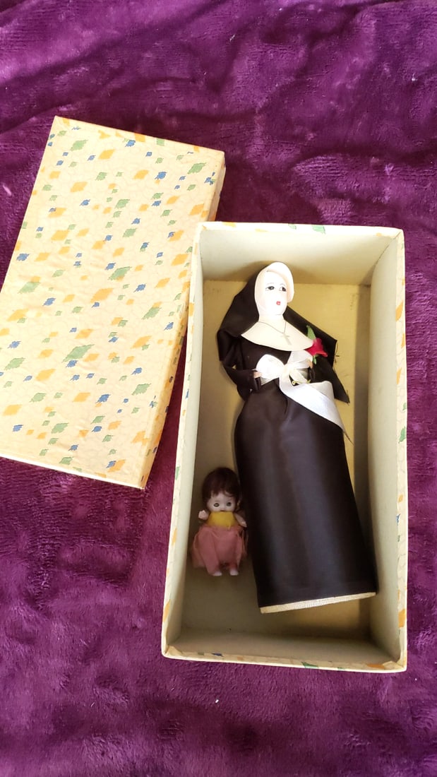 Religious Nun Doll In Black Habit With Cross Necklace And Pink Rose, Baby Doll, In Midcentury Box: 10x5. 5x4 1lb Low Estimate: 15.00 High Estimate: 75.00