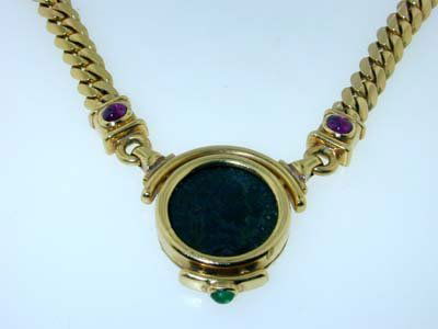 Bvlgari 18K Yellow Gold Ancient Coin Necklace: Beautiful Bvlgari 18K Yellow Gold Ancient Coin Necklace with Ruby and Emerald! This necklace is 15" in length. The coin is 20 mm in diameter. The thickness of the pendant is 5 mm. The weight of the ne