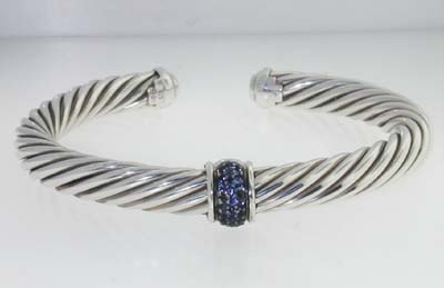 David Yurman Silver Sapphire Bangle: David Yurman Silver Sapphire Bangle. The total Bangle 's weight is 41.0 grams. The total sapphire weight is 0.5 cts approxmiately. The bangle size is 60x43 mm. 7 mm in thickness.
