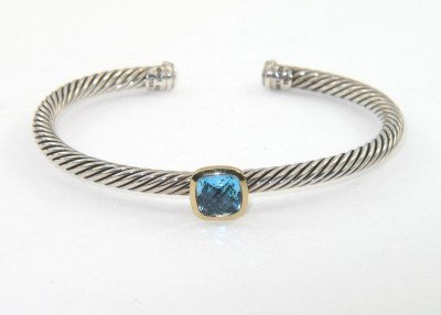 David Yurman 18k Yellow Gold/Silver, Blue Topaz Ban: David Yurman 18k Yellow Gold/Silver Blue Topaz Bangle Bangle's Weight : 18.3 grams. The size of the Blue Topaz is 5 x 5 mm. The measurements of the Bangle: 49 x 41 mm and the thickness is 3 mm. There 