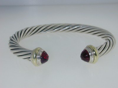 David Yurman Silver 14K Yellow Gold Garnet Bangle: David Yurman Silver & 14K Yellow Gold Garnet Bangle. Bangle's Weight :31.8 grams. The size of garnet : 8 x 5 mm The measurements of the Inside Bangle are 55 x 45 mm and the thickness is 7 mm. There is
