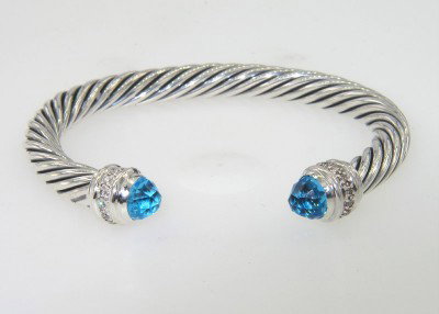 David Yurman Silver Blue Topaz & Diamond Bangle: David Yurman Silver Blue Topaz & Diamond Bangle.The total Bangle's weight is 39.4 grams.The total diamond weight is 0.48 cts approximately, I color SI clarity.The size of the blue topaz is 7 mm, each.
