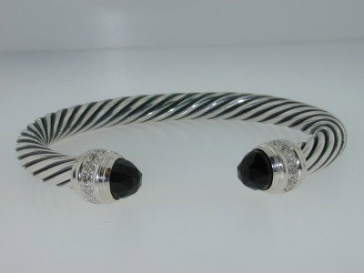 David Yurman Silver, Onyx & Diamond Bangle: David Yurman Onyx & Diamond Bangle in Silver.The total Bangle 's weight is 45.3 grams.The total diamond weight is 30 pts approxmiately,H color VS clarity.The size of the Onyx is 7x7 mm, each.The bangl