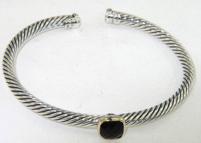 David Yurman Gold / Silver Onyx Bangle: David Yurman 18K Yellow Gold / Silver Onyx Bangle The total Bangle's weight is 19.4 grams. The measurement of onyx: 6 x 6 mm. The bangle size is 49 x 42 mm. 3 mm in thickness.