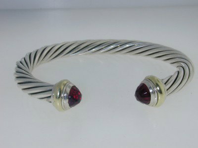 David Yurman Silver 14K Yellow Gold Garnet Bangle: David Yurman Silver & 14K Yellow Gold Garnet Bangle. Bangle's Weight: 31.8 grams. The size of garnet : 8 x 5 mm The measurements of the Inside Bangle are 55 x 45 mm and the thickness is 7 mm. There is