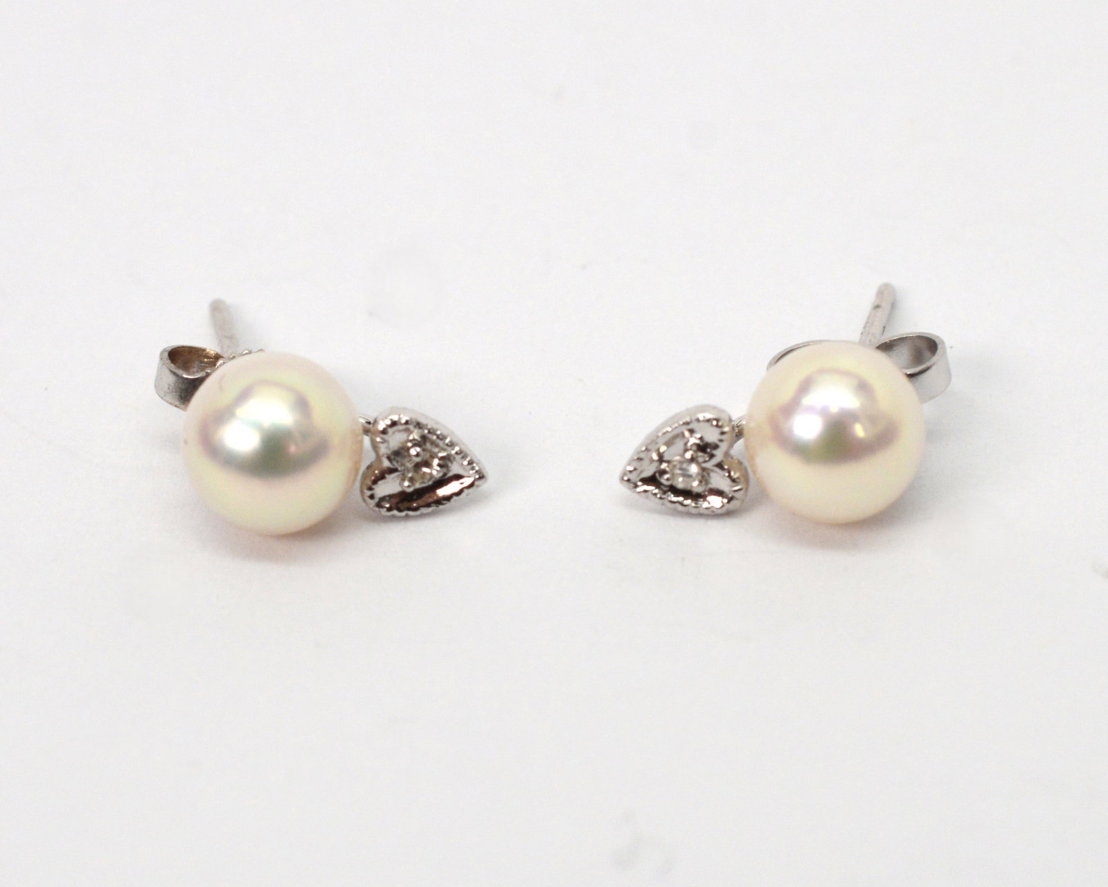 14K WG Akoya White Pearl & Diamond Stud Earrings: 14K WG Akoya White Pearl & Diamond Stud Earrings. Pearls are 6.5/6.75MM. White gold heart detail contains a .05CT diamond. Post for pierced ears. New In box. EB3786/EDX