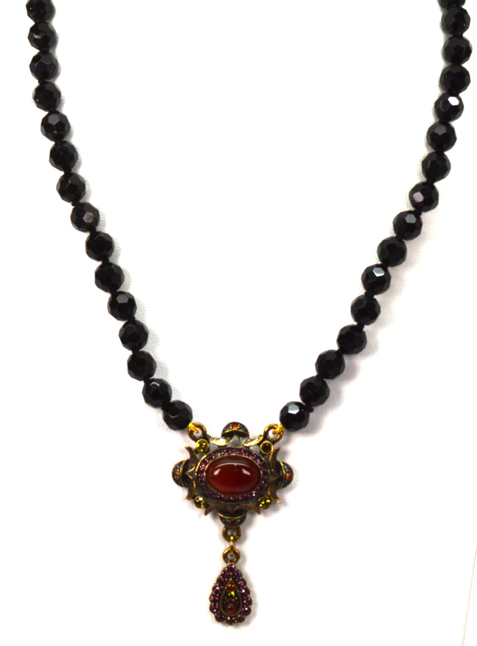 Heidi Daus Jet Bead Necklace Carnelian Cabochon Multi Color Crystal Enhancer: "Heidi Daus Jet Bead Necklace Carnelian Cabochon Multi Color Crystal Enhancer. Single strand of 8MM facetedcut black beads, 14"" with a 4"" extender. Pendant has a large carnelian cabochon surrounded