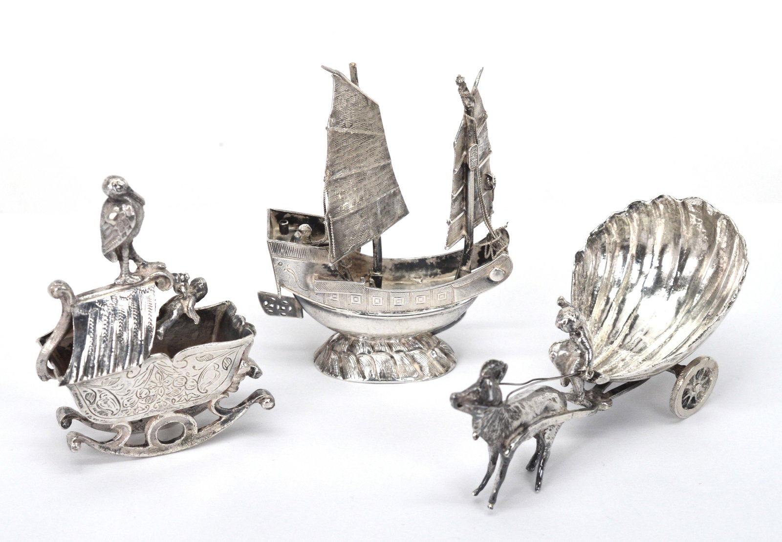 Antique Silver Novelty Collectables Items 3 Pieces: Antique Sterling Silver & Hanau Silver Novelty Collectables. Chinese Junkboat is 3' high and 2.25" wide. Very detailed construction. The cherub and goat pulling cart is 1.5" high and 3.25" wide. It mi