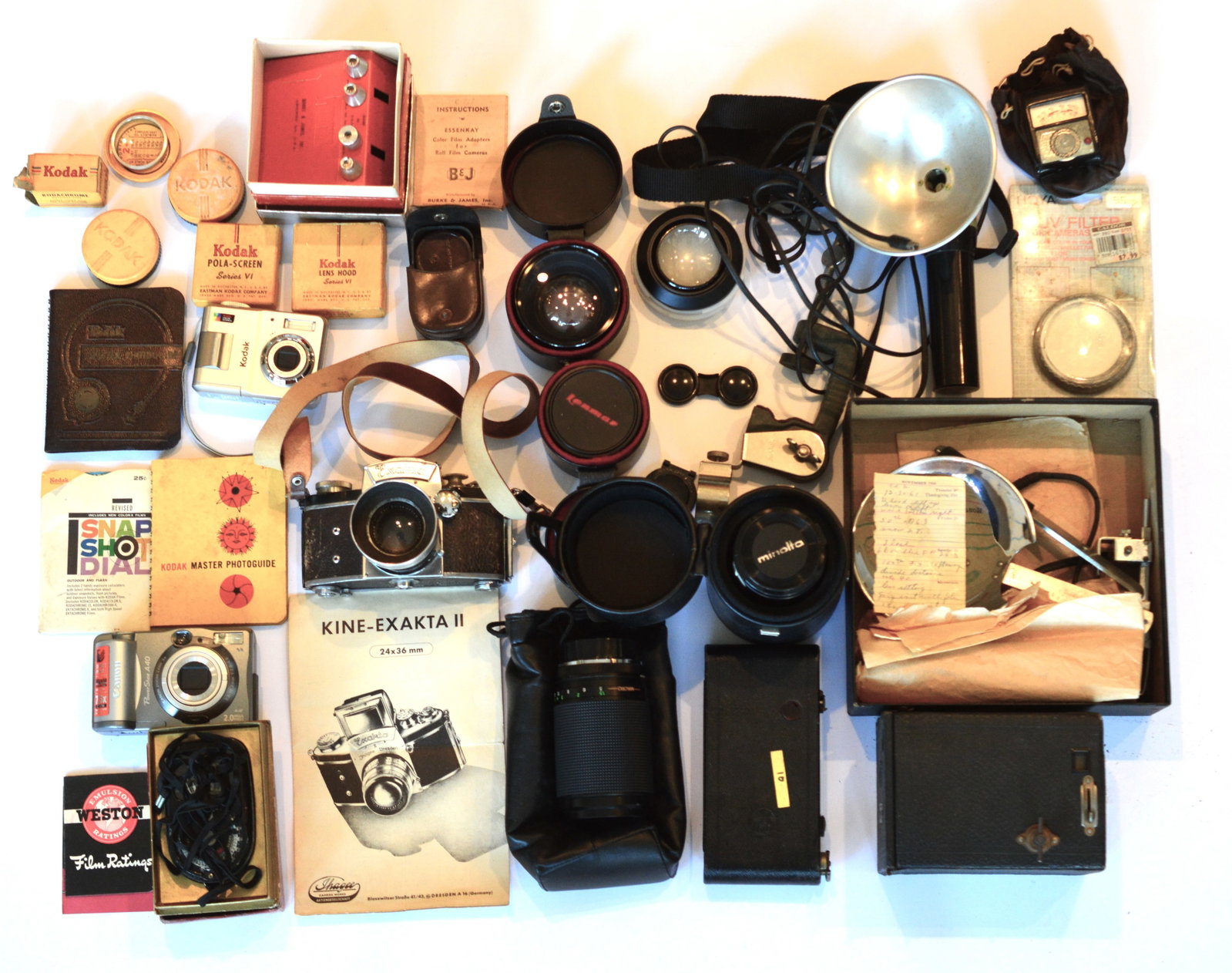 Vintage Lot of Cameras Lighting Lenses Accessories Guides: Vintage Lot of Kodak Brownie Cameras, Exakta 35MM camera, Kodak & Canon digital cameras, 4 lenses, meters, filters, guides, film, flash gun and light. For collectors, repair or parts. AS IS S/