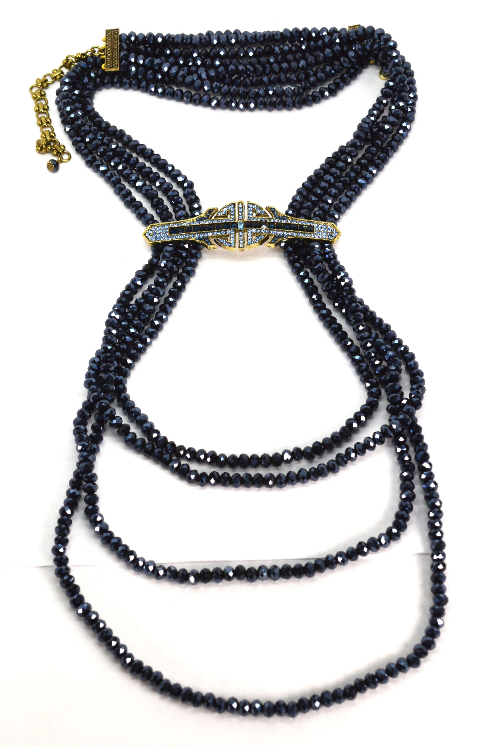 Heidi Daus 4 Strand Deep Blue Denim & Deco Necklace: Heidi Daus 4 Strand Deep Blue Denim & Deco Necklace. High shine deep blue faceted beads are 6MM. The fixed crystal pendant is 3.75" wide and 1" high. Necklace measures approximately 23.5" long x 1" wi