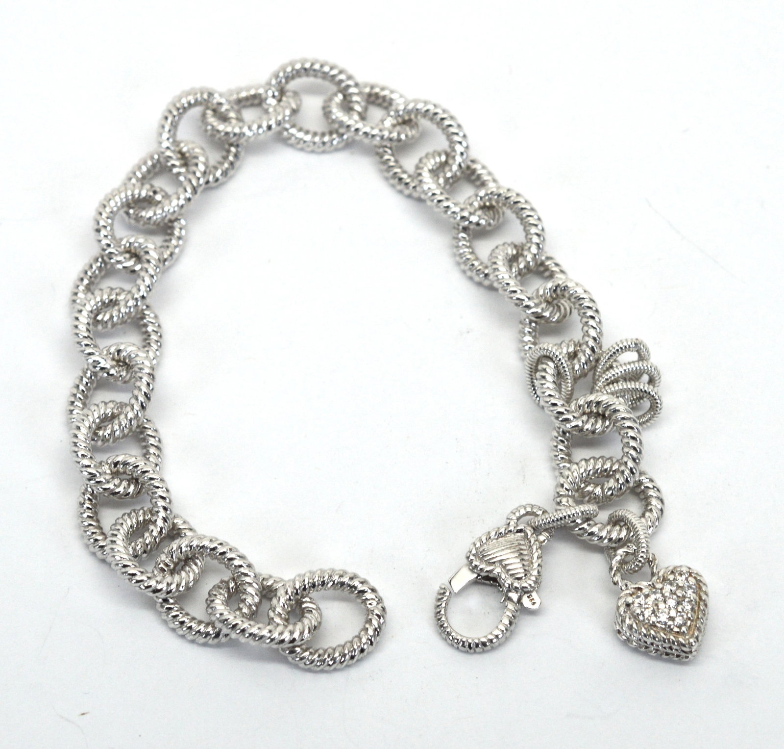 Judith Ripka Sterling Silver 7" Charm Bracelet: Judith Ripka Sterling Silver 7" Charm Bracelet. Bracelet contains four rings to add charms. There is a puffy heart charm with crystal detail. Large, secure lobster closure with heart detail. The links