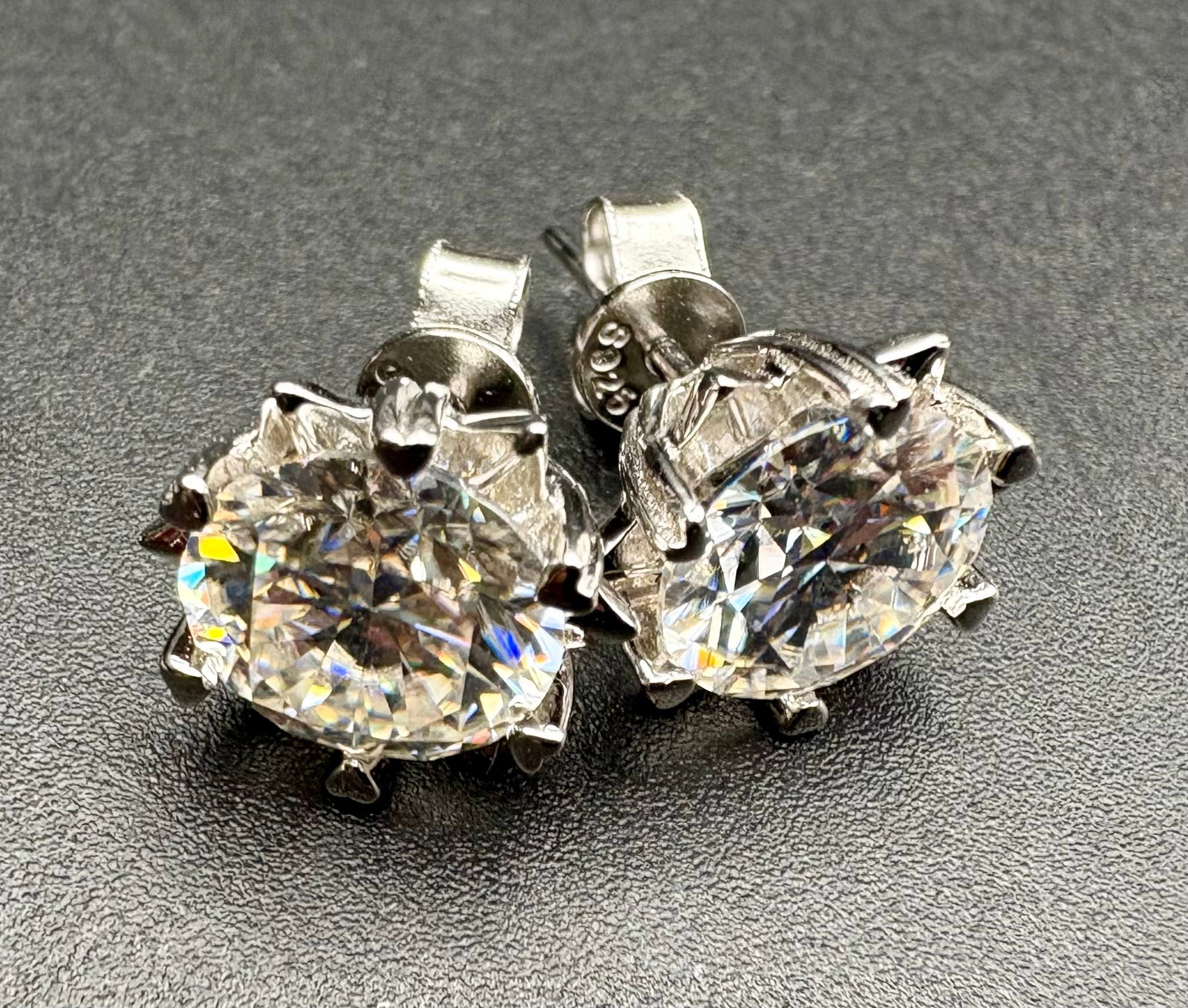 Moissanite Stud Earrings Oval Cut, Brilliant Shine, Certified: A stunning pair of oval-cut Moissanite stud earrings with exceptional fire and brilliance. Each stone is securely held in a high-polished silver-tone prong setting, designed to maximize light reflecti
