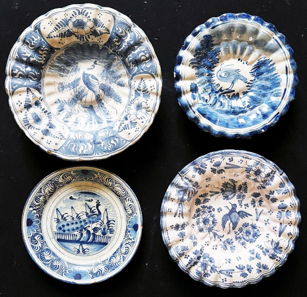 4 plates or fan plates, faience, 18th/19th century,: 4 plates or fan plates, faience, 18th/19th century, various regions, amongst others Hanau, signs of age, some chips, hairline cracks, etc., blue decoration on a light background, mirror and flags rich