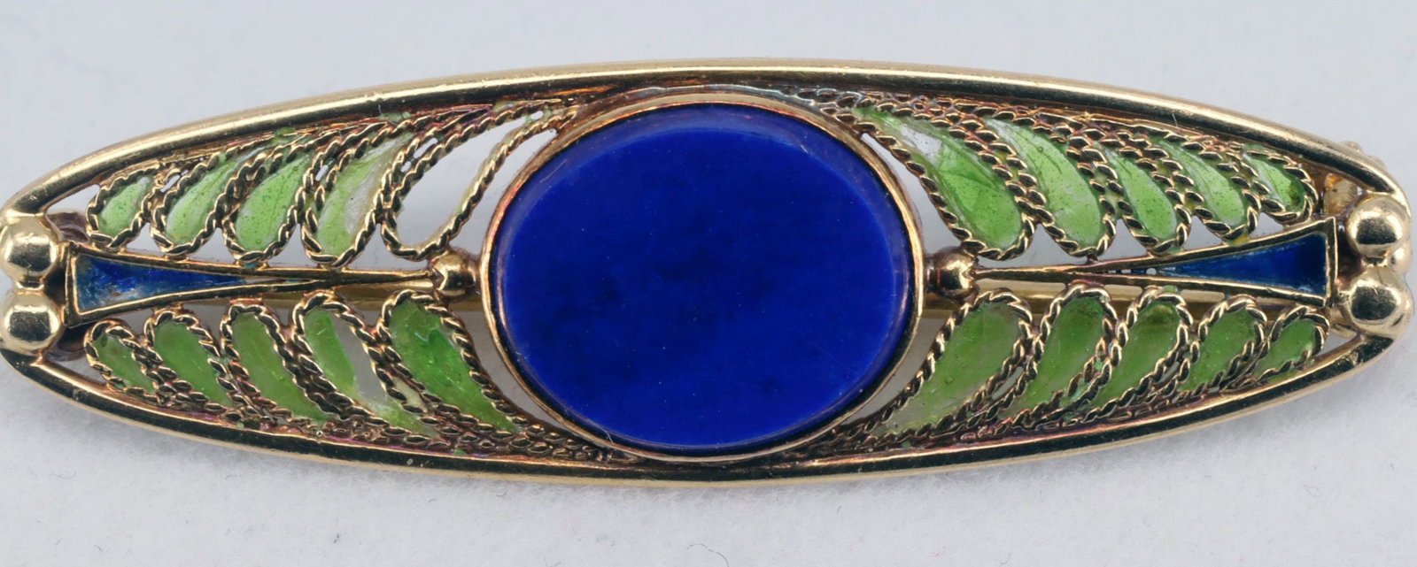 Tiffany, probably early 20th c., Art Nouveau brooch: Tiffany, probably early 20th century, Art Nouveau brooch, 18-karat gold (tested), 5.2 g. Oval with decorations in light green and blue cloisonné enamel, partially damaged, with an oval lapis lazu