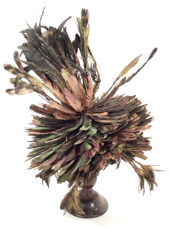 Bamileke Juju Feathered Headress From Cameroon: 15 1/2"Dia. x 16"H. Feather colors faded, some losses and breakage. Supported on later turned wood stand. Provenance: Collected by Sophia and Roy Sieber.