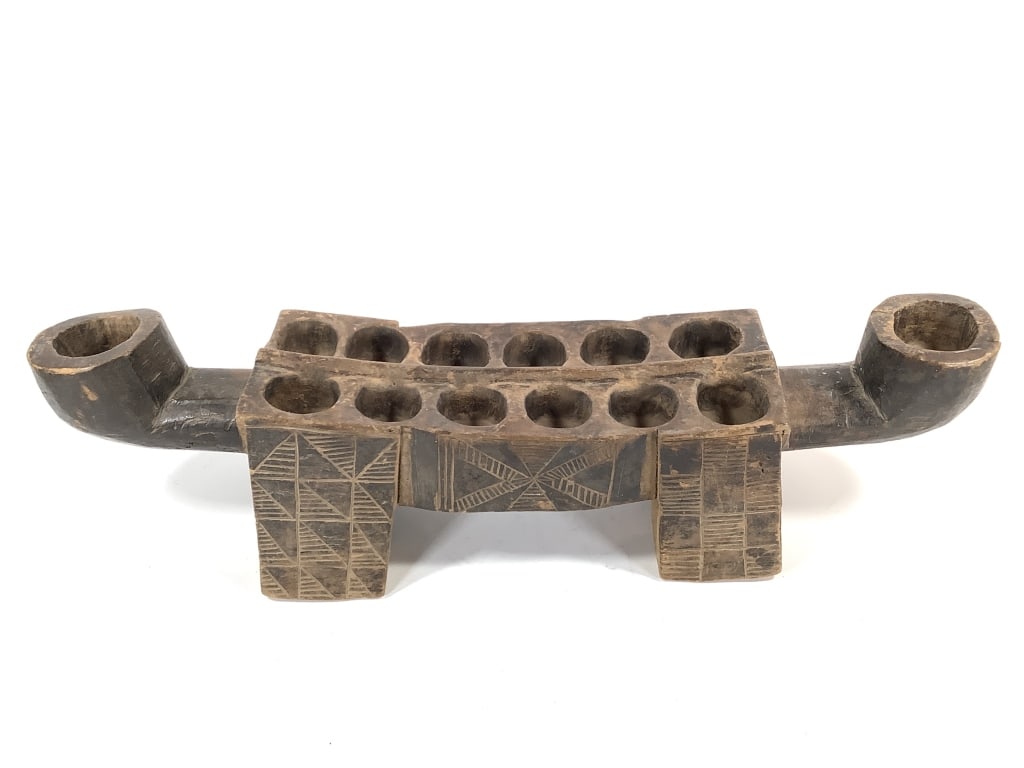 Wood Carved Mancala Game Board: 25 1/2"L x 5 1/2"W. Provenance: Collected by Sophia and Roy Sieber.