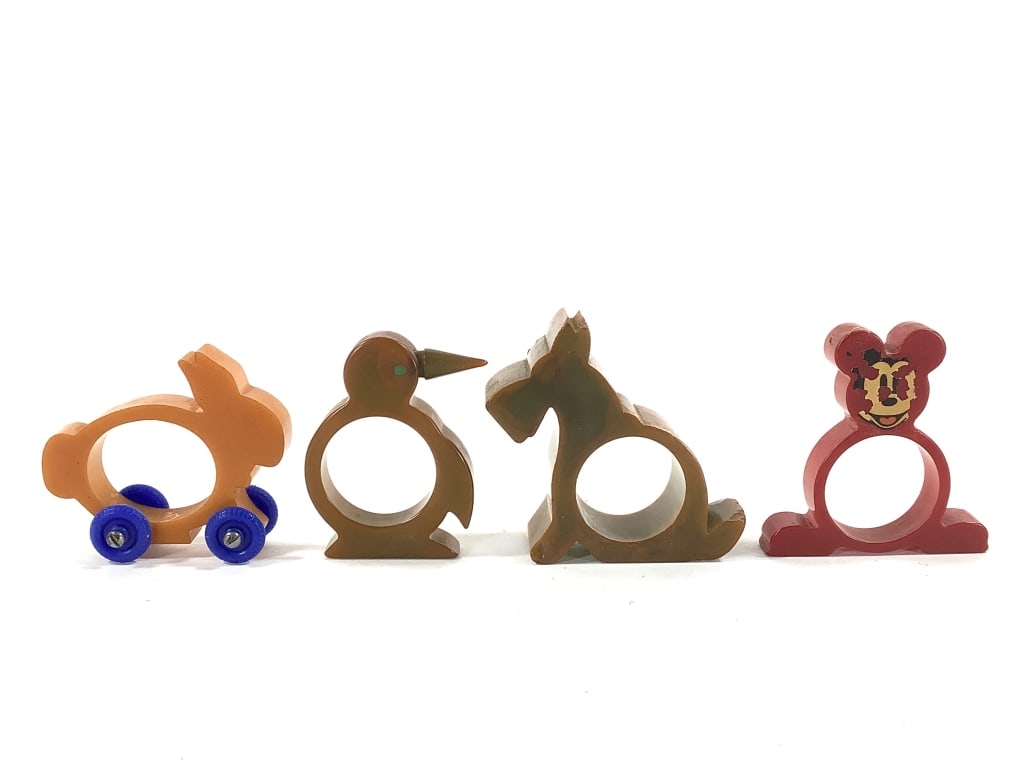 4 Bakelite & Catalin Animal Napkin Rings: 1930-40s era. Yellow rabbit on wheels, red Catalin Mickey Mouse with remnants of face decal, rare - marbled penguin with painted green eye (original color on bottom is green, oxidation change to brown