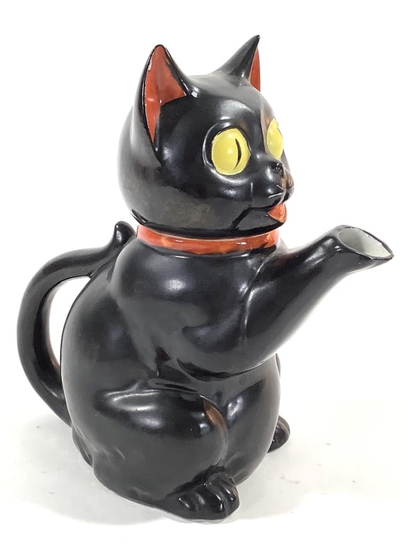 Black Cat Porcelain Teapot Japan 1950-60s: 7 1/2"H. Black cat with yellow eyes, red ears, mouth and bow tie. Stamp mark over glaze "Made in Japan". Likely Kasuga ware or similar. Provenance: Collection of William and Diane Itter.