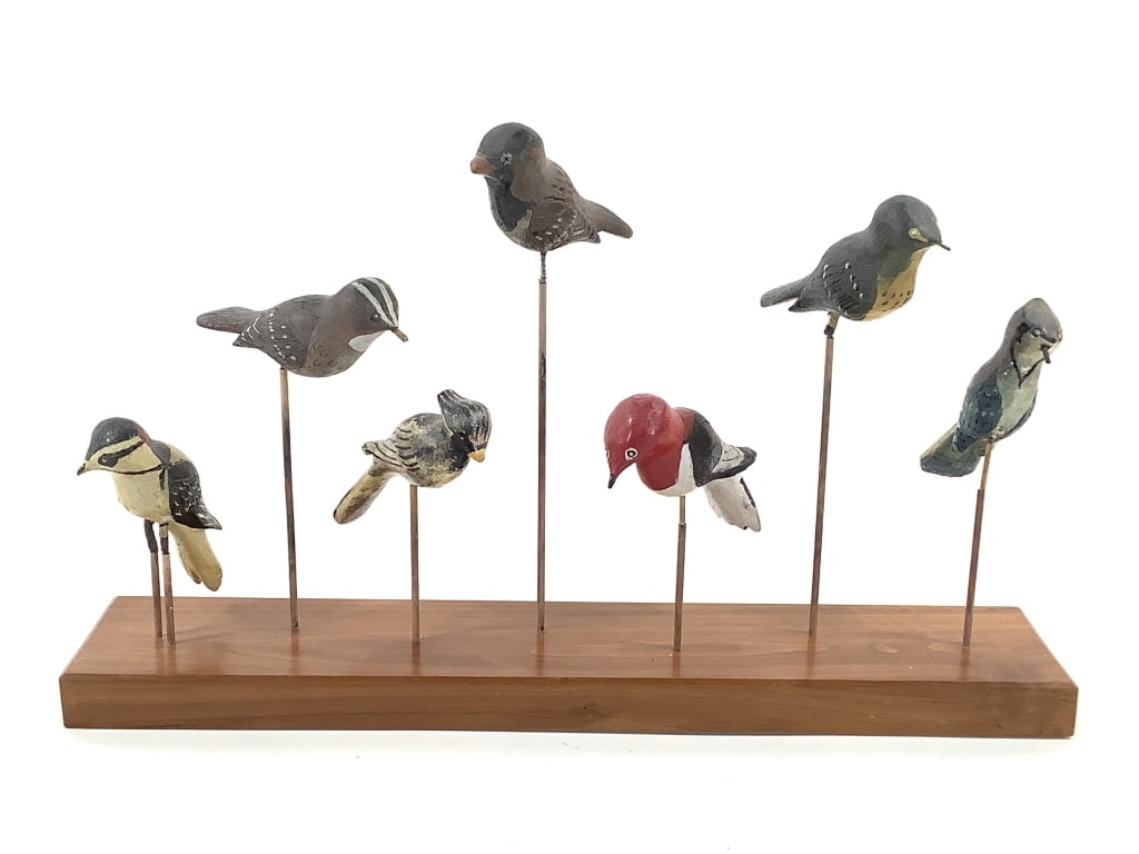 7 Hand Carved & Painted Folk Art Birds w Stand: 6" x 3" custom cherry wood stand by William Itter with folk art birds by unknown craftsmen, removable. Birds approx. 4"L. Provenance: Collection of William and Diane Itter.