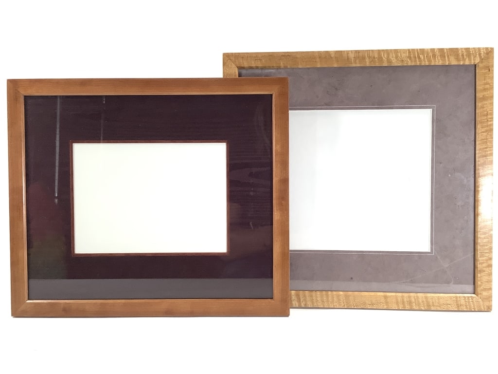 2 Picture Frames by Wm Itter Cherry & Maple: 12 5/8" x 10 3/4" solid cherry wood frame with burgundy moire silk back and matt. 12 1/4" x 12" solid figured maple wood frame with matt. Provenance: Collection of William and Diane Itter.