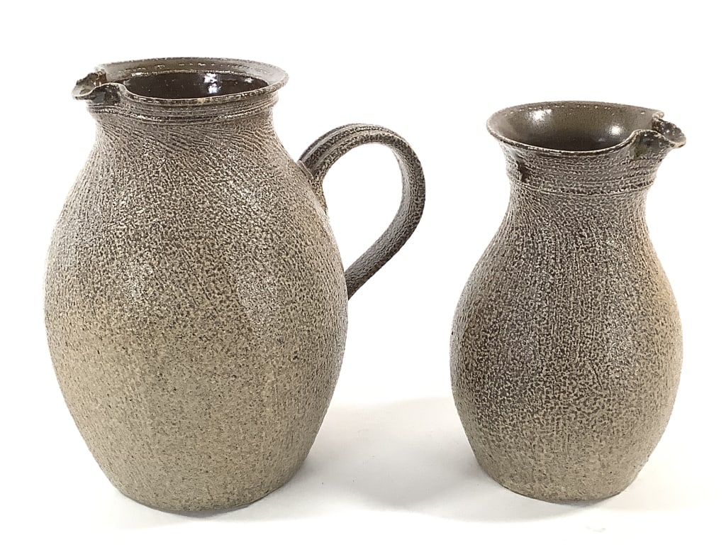 Stoneware Pitchers Studio Art Pottery: 6 7/8"H and 7 3/4"H. Textural glaze on exterior. Signed illegibly on bottom of pitcher without handle. Provenance: Collection of William and Diane Itter.