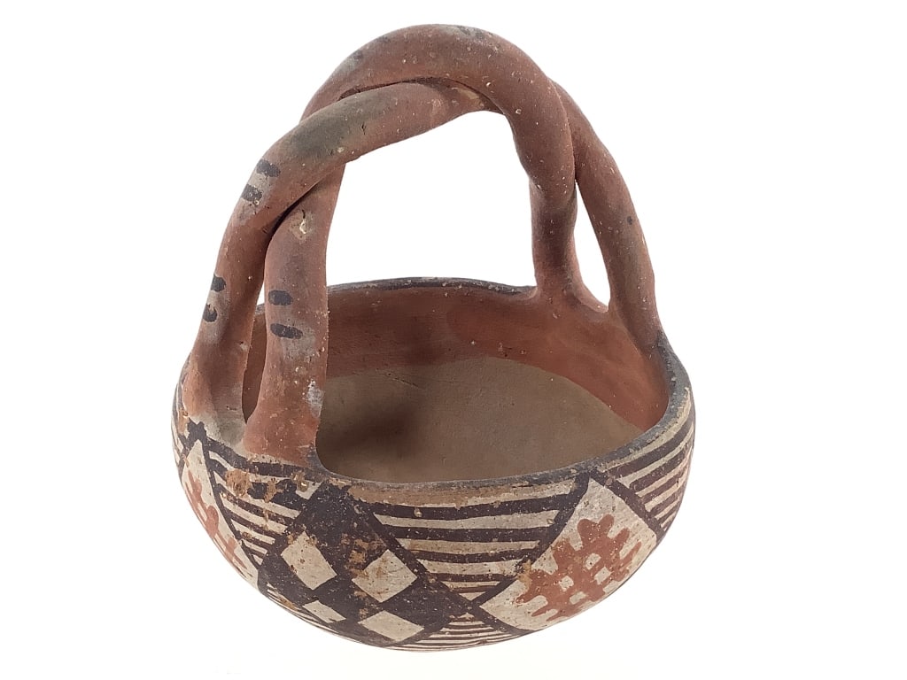 Pueblo Polychrome Pottery Basket w/ Twisted Handle: 4 1/2"W x 5 1/2"H (handle included in measurements). Shows paint loss, surface pitting and cracking consistent with the items age. Structurally intact. Provenance: Collection of William and Diane Itte