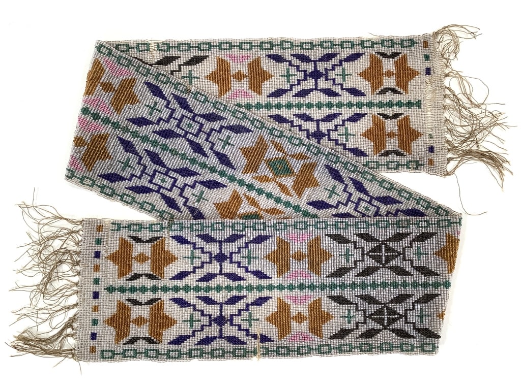 Loom Beaded Geometric Bandolier Strap: 33 1/2"L. Loose threading / bead loss in several small areas. Beadwork is largely intact, with intricate multi-color geometric patterns. Provenance: Collection of William and Diane Itter.