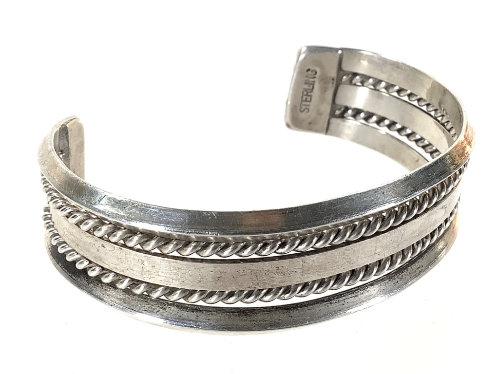 Sterling 5 Band Cuff Bracelet 34.6g TW: 6" L. 2 twisted rope bands bounded by dimensional outer bands and flat center band. Marked sterling at end.