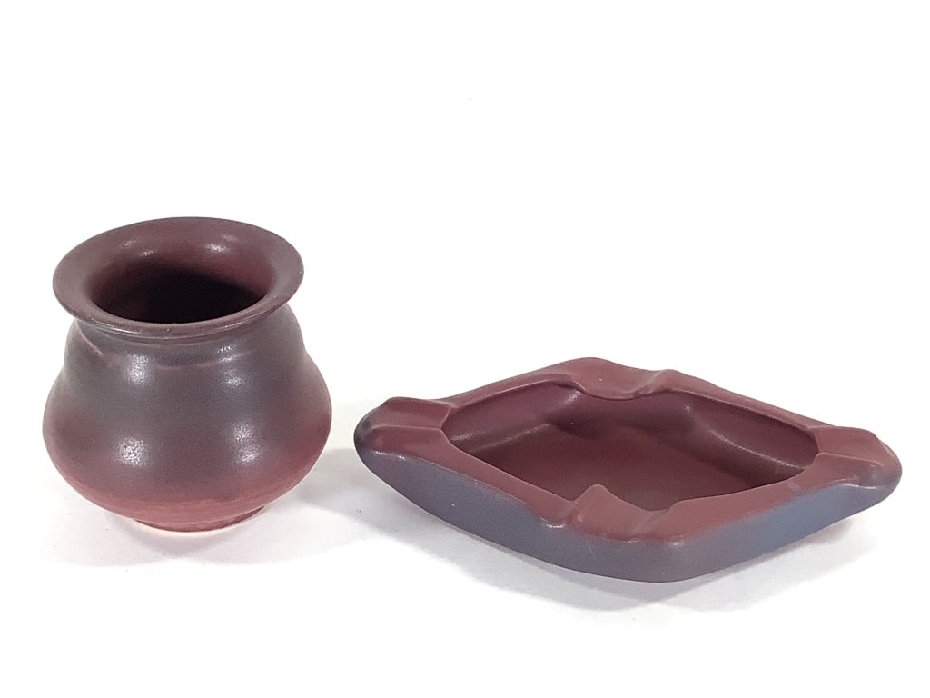 Van Briggle Pottery Ashtray & Matching Cup: 7" x 4" ashtray in Arts and Crafts Diamond shape, Persian Rose / Mulberry matte glaze. Incised hand drawn mark on bottom. 3"H cigarette cup in a similar glaze. Unmarked, small glaze nicks at rim.
