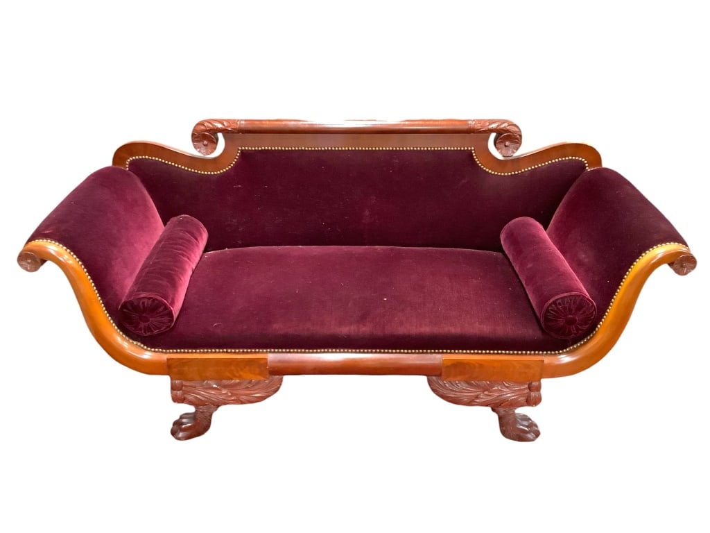 Antique American Empire Revival Settee: 72"L x 24 1/2"D x 34 3/4"H. Mahogany frame with burgundy velvet upholstered seat and back with roll arm cushions. Winged lion paw carved legs. Overall very good condition, minimal wear. No visible