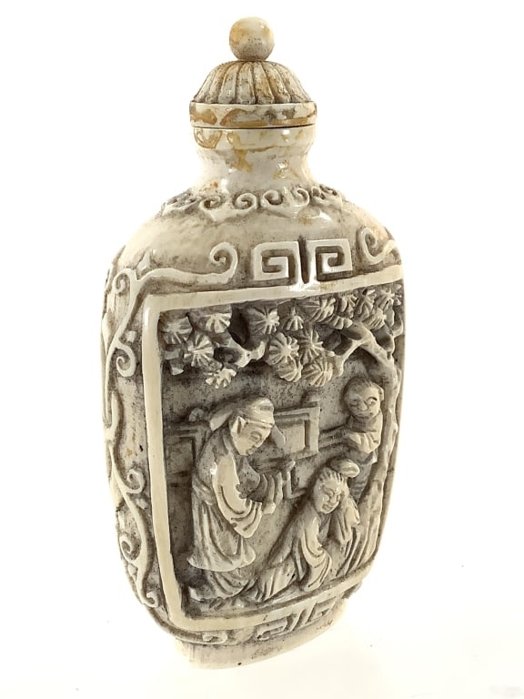Two Scenes Carved Ivory Snuff Bottle: 3 1/4"H ivory snuff bottle with two carved scenes on the face and a spoon. Residue present around the top, artist marked on the base.