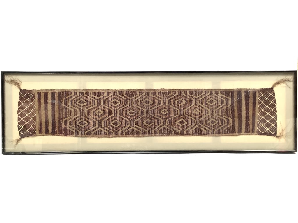 Framed Congolese Kuba Raffia Fiber Textile: Frame 40 1/2" x 11"W, textile 35 1/2"L x 6 1/2"W. Piece has been displayed in frame, behind glass. Panel is structurally intact, with no visible holes or major damage. Minor breakage in lower left
