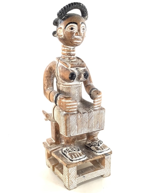 Fante Ghana Wood Seated Female Figure Sculpture: 21 3/8"H x 7 1/4"w x 7 5/8"D. Carved wood with white pigment wash over the surface. Crack along right side from chest to base of chair. Provenance: Collection of William and Diane Itter. Please see