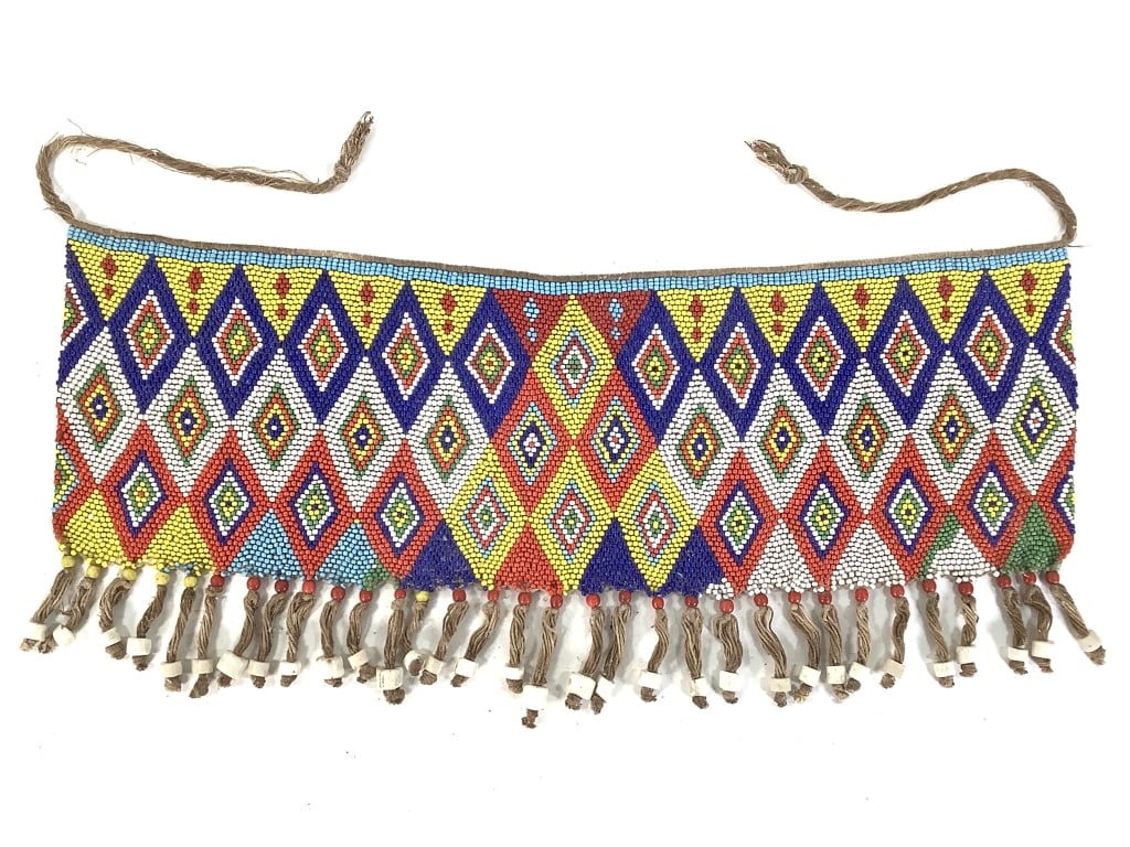 Kirdi Beaded Apron Cameroon Diamond Grid: 19 3/4"W x 8 1/2, excluding tie. Kirdi beaded apron with a geometric diamond grid pattern and beaded fringe. Some wear on the tie. Provenance: Collection of William and Diane Itter. Please see photos