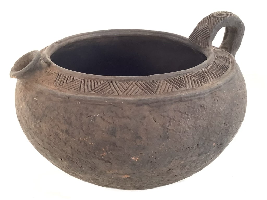 Bamileke Pitcher w Handle Cameroon: 11 1/2"Dia. 12 1/2 with handle. 8 1/8"H. Few chips at the spout. Provenance: Collection of William and Diane Itter. Please see photos for condition and details. Please note: Some pots may have