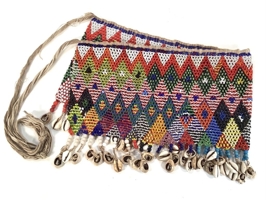 Kirdi Beaded Apron Cameroon Multi Colored Diamond: 27" x 9" excluding apron tie. Kirdi beadwork apron with an intricate multicolored diamond pattern with cowrie shell and larger beads for fringe. Some wear on the rope apron tie. Provenance: