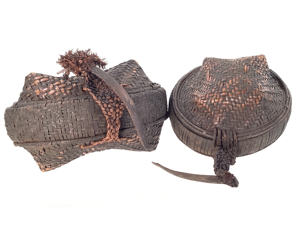 2 Kuba Lidded Basket Africa: 2 smaller Kuba food baskets with lids. Larger oval basket, 6 1/2"W x 5 1/8"D x 4"H. Small basket has loose stitching at base edge of lid. Provenance: Collection of William and Diane Itter. Please see