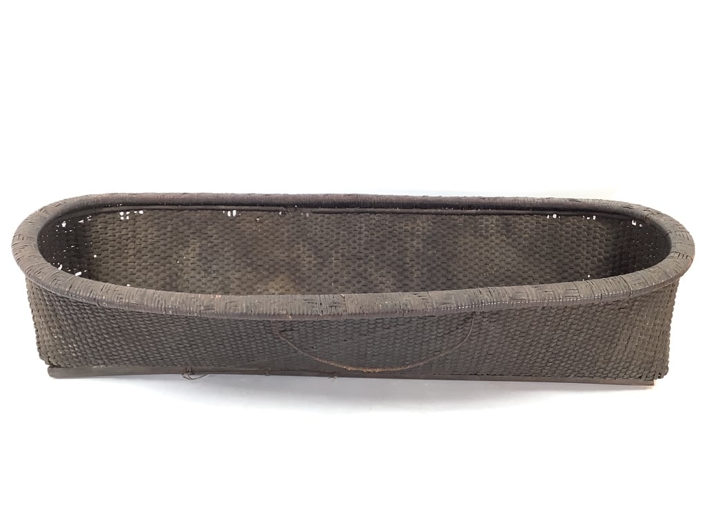 Cameroon Storage Basket Lg Elongated Oval: 34 1/4"W x 13"D x 8"H. Large woven elongated oval basket with 2 inner and 2 outer reinforcing wood splits along length. Split on 1/3 of one of the inner rails. splits and loss at the ends of the