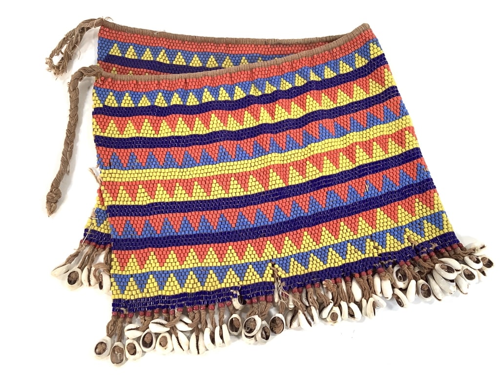Kirdi Beaded Apron Cameroon: 23"W x 10 3/4"H excluding apron tie. Kirdi beadwork apron with an diamond strip geometric pattern, and cowrie shell fringe at the bottom. Bottom edge has splits in the weave/ prior damage. Appears to
