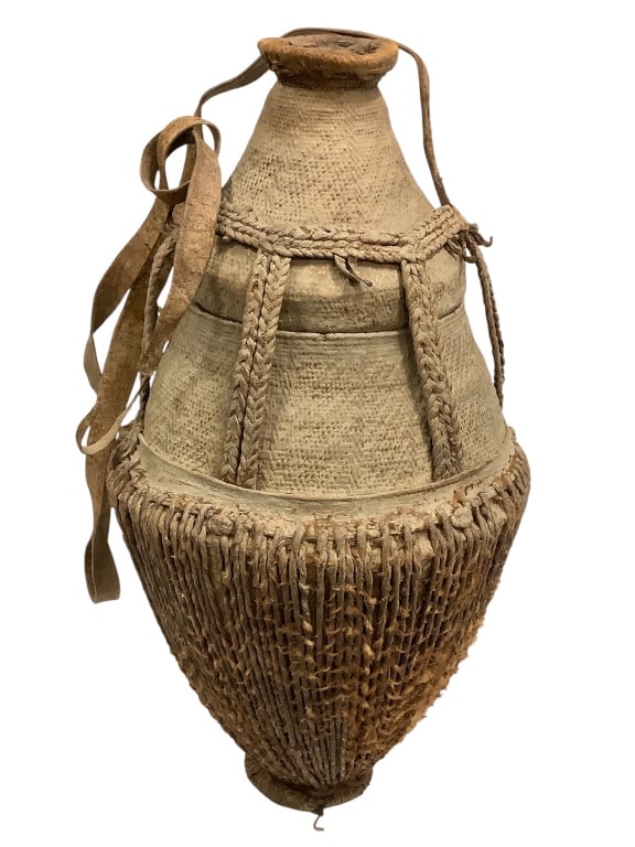 Somali Milk Container Woven Fiber w Leather Strap: 22" x 10". Fair condition, minor loses. Provenance: Collection of William and Diane Itter. Please see photos for condition and details.