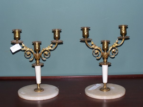 Alabaster and Bronze Candlesticks: Pair of alabaster & bronze dore candlesticks. Cream alabaster & bronze leaf candlestick. Each candlestick is decorated in bas relief, as is the base. 11" tall x 6.75" wide.