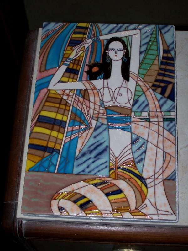 An 8" x 12" handpainted porcelain tile: by Ting Kwan of woman in reeds in vibrant colors of blues, greens, camels, pink, ivory & black. Can be framed or inserted into walls.