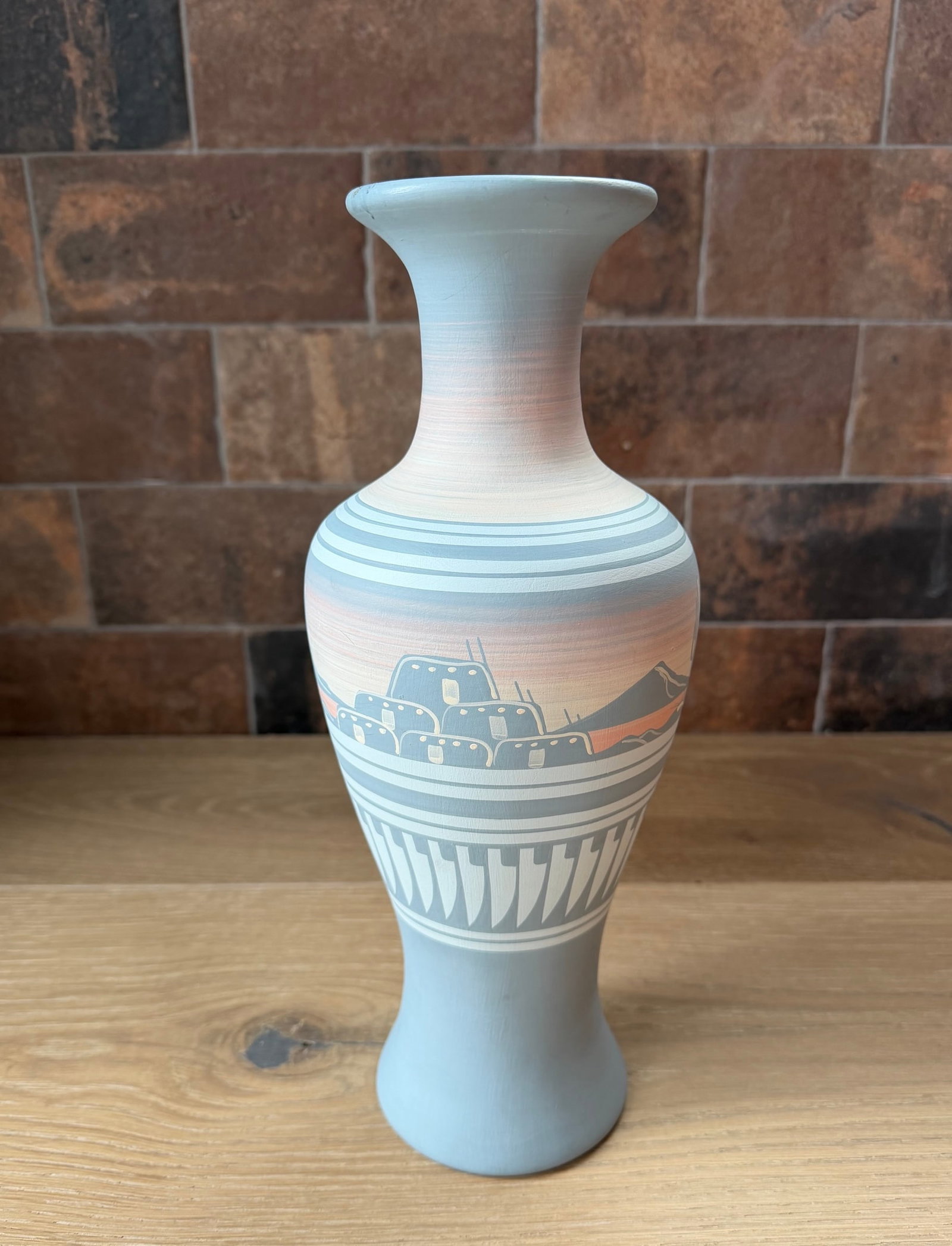 Mesa Arizona Navajo Vas labeled MM125 On Bottom: This elegant hand-thrown pottery vase captures the serene beauty of a Southwestern landscape at dusk. The graceful, elongated form features a soft matte light blue-gray base that transitions into warm