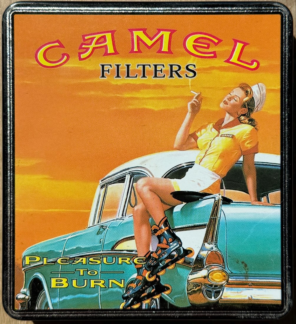 Vintage Camel Filters “Pleasure to Burn” Metal Tin / Sign – Pin-Up Girl on Classic Car: Collectible Camel Filters promotional metal tin featuring a retro pin-up style illustration of a rollerblading carhop sitting on a classic turquoise car against a sunset backdrop. Bold “CAMEL FILTER