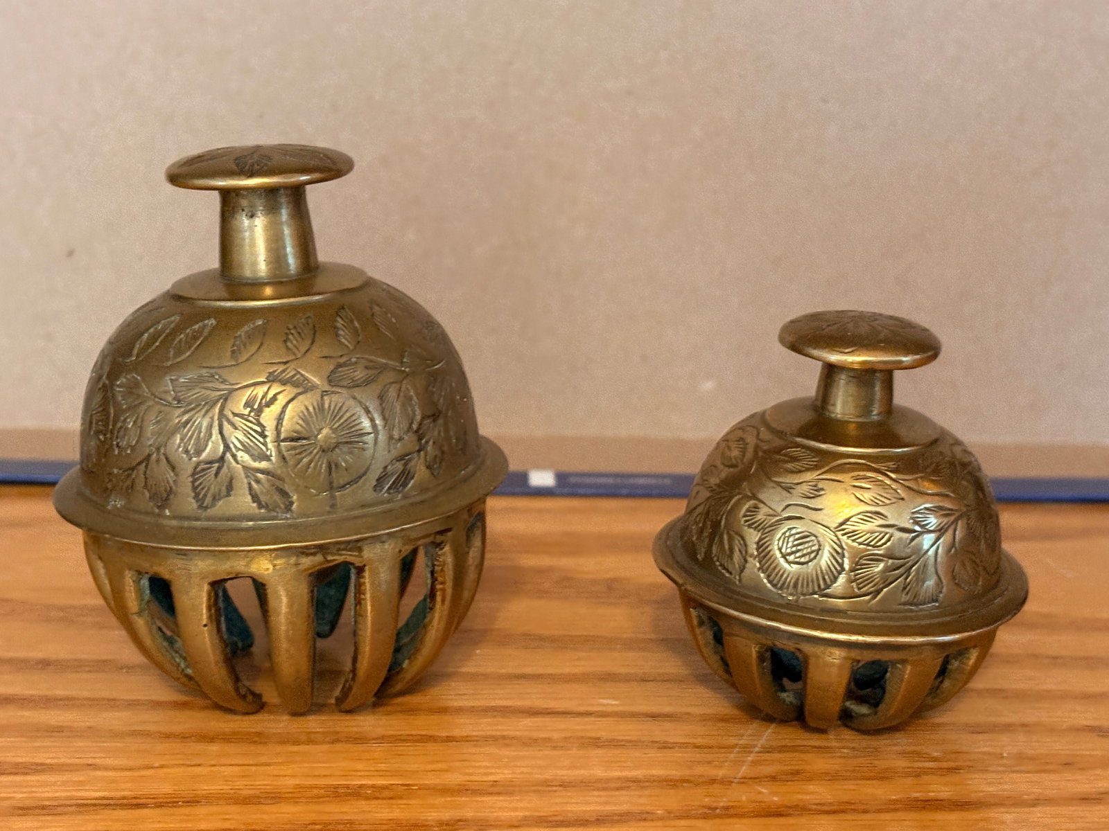 Pair of Antique Brass Church Bells: A matched pair of solid metal church bells, well-cast and nicely weighted, producing a clear, loud ring. Warm golden surface with natural wear and polish from long use. Decorative pierced bodies with